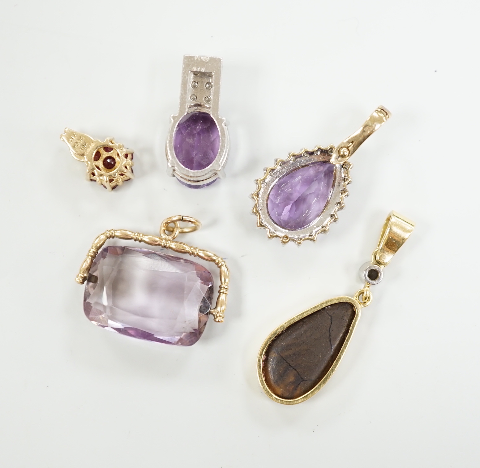 A white metal, stamped PT900, amethyst and diamond cluster set pendant, 18mm, gross weight 5.5 grams and four other pendants including three 9ct and gem set and a yellow metal and simulated opal and diamond, gross 13 gra